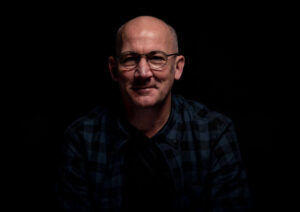 James Fowler Voiceover head shot with a dark background