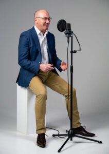 Full length shot of James Fowler voiceover smiling into the mic.